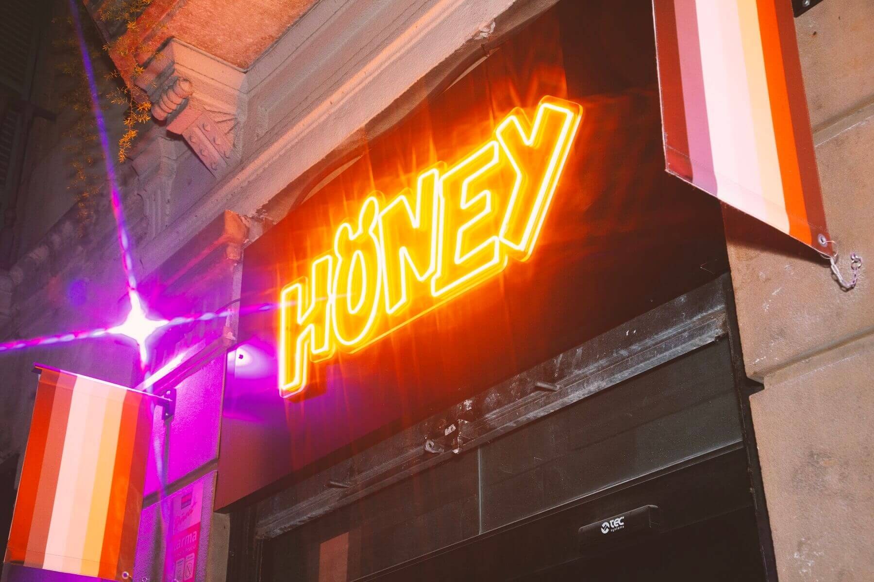Neon Honey sign over the bar entrance at night