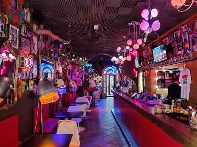 Bar counter with pink globe lights at Priscilla