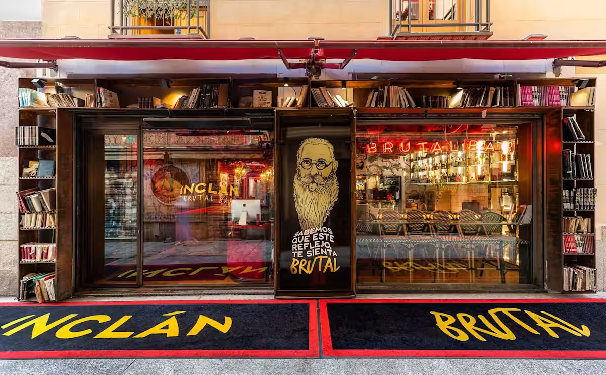 Street facade of Inclán Brutal Bar with bookshelves and neon signage