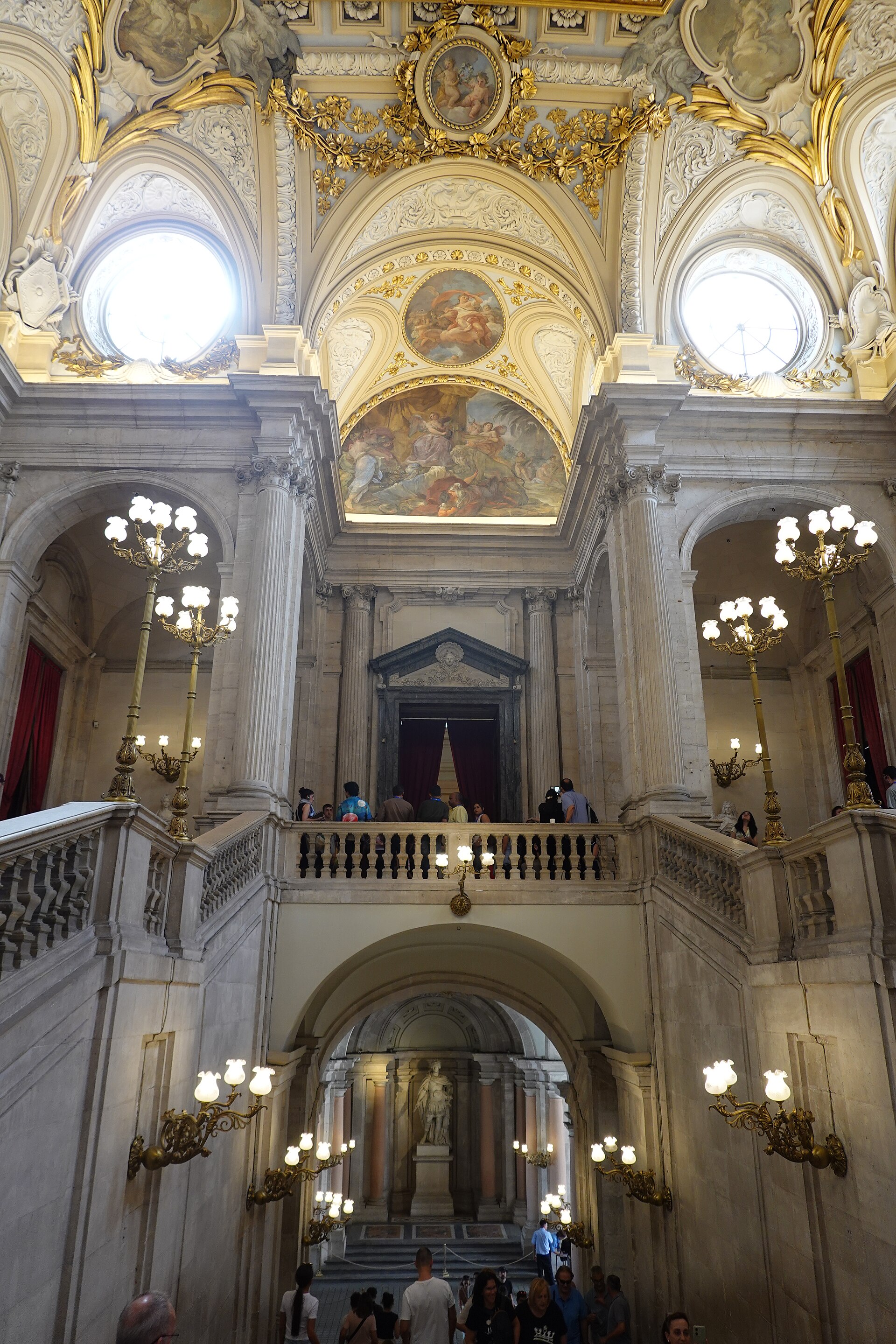 The grand staircase inside the Royal Palace of Madrid with frescoed ceiling