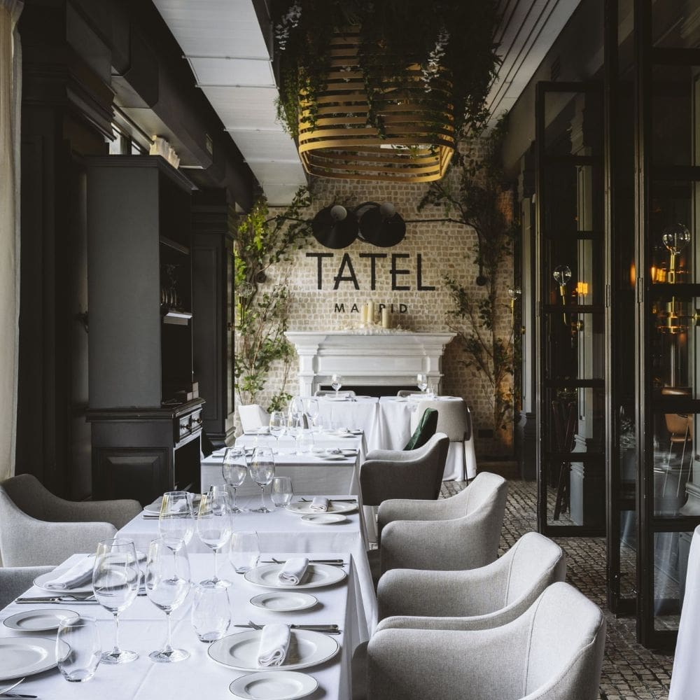 Dining room at TATEL Madrid with set tables beneath the TATEL Madrid sign